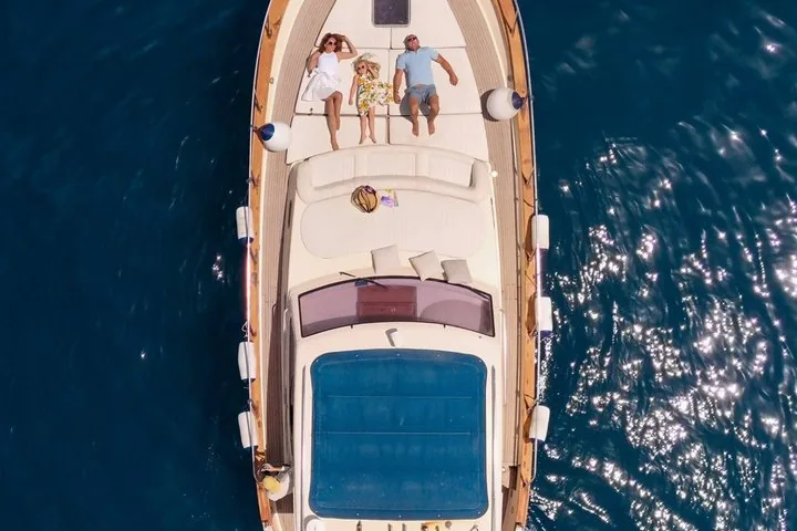 Family relaxing on the bow of a boat in the open sea.